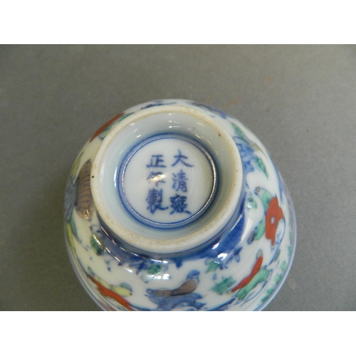 452 - A pair of Chinese Doucai enamel tea bowls decorated with boys playing in a garden, 6 character mark ... 