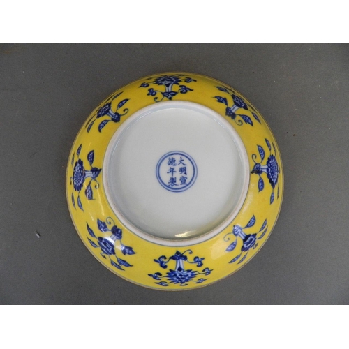 465 - A Chinese yellow ground porcelain cabinet plate with floral decoration in the blue and white palette... 