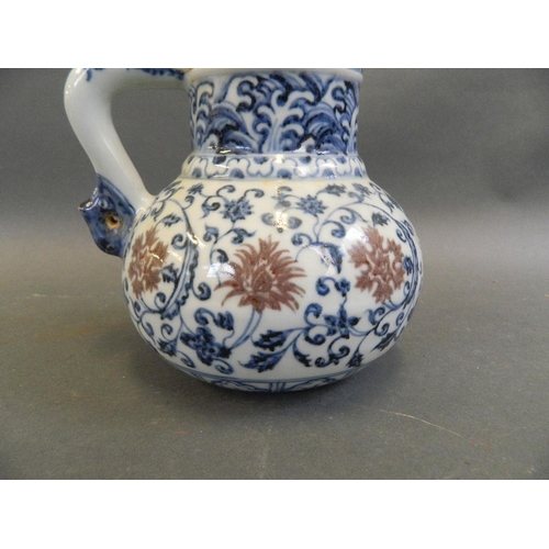 473 - A Chinese Ming style blue and white water jug with scrolling floral decoration and red highlights, t... 