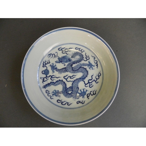 49 - A Chinese blue and white porcelain dish decorated with a dragon chasing the flaming pearl, 6 charact... 