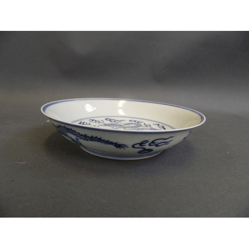 49 - A Chinese blue and white porcelain dish decorated with a dragon chasing the flaming pearl, 6 charact... 