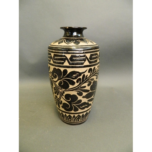 50Z - A Chinese black ground pottery vase in the Cizhou kiln style with chased floral decoration, 10