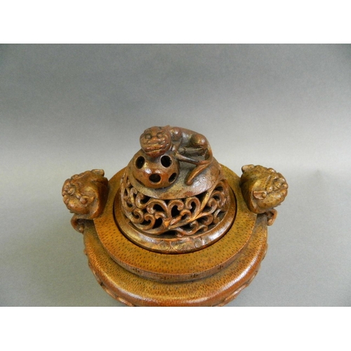 51 - A Chinese bamboo censer with carved twin dragon mask handles and pierced kylin knop, on tripod feet,... 