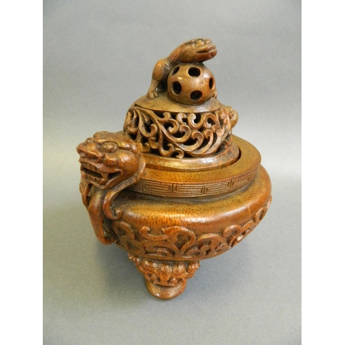 51 - A Chinese bamboo censer with carved twin dragon mask handles and pierced kylin knop, on tripod feet,... 