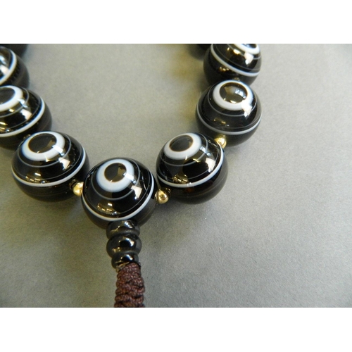 510 - A string of black banded agate eye beads, 16½