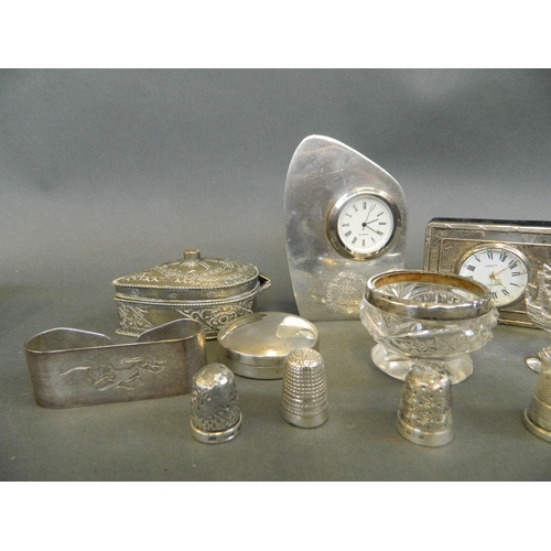 514 - A collection of small silver and silver plate items including two desk clocks, five thimbles, miniat... 