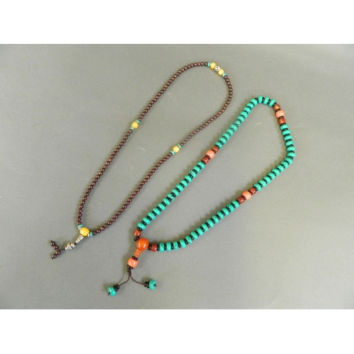 526 - A string of turquoise style beads with amber style feature beads, together with a string of garnet s... 