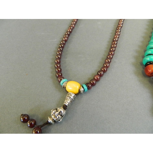 526 - A string of turquoise style beads with amber style feature beads, together with a string of garnet s... 