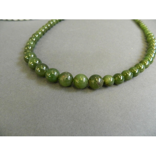 530 - A green bead necklace, together with a graduated green jade bead necklace, longest 30