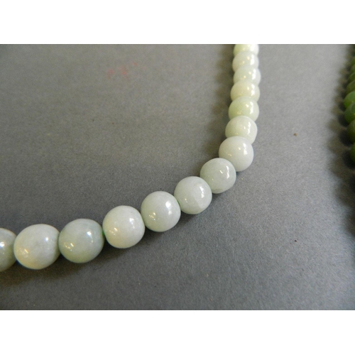 530 - A green bead necklace, together with a graduated green jade bead necklace, longest 30