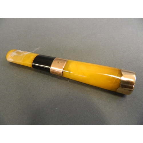 549 - A 9ct gold mounted and reconstituted amber cheroot holder, cased, 4