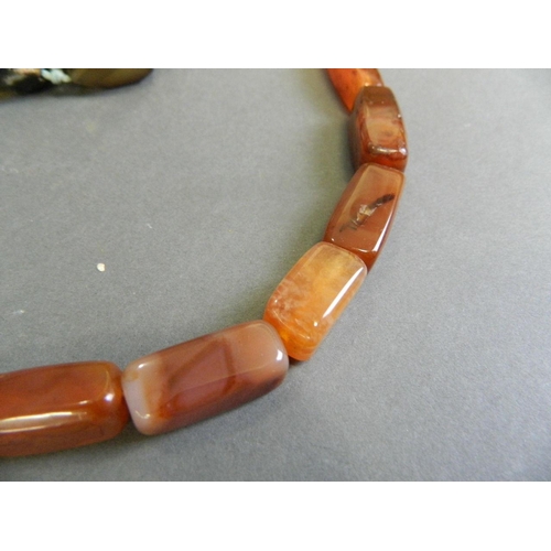 576 - A cornelian graduated bead necklace, together with a natural agate bead necklace, longest 42