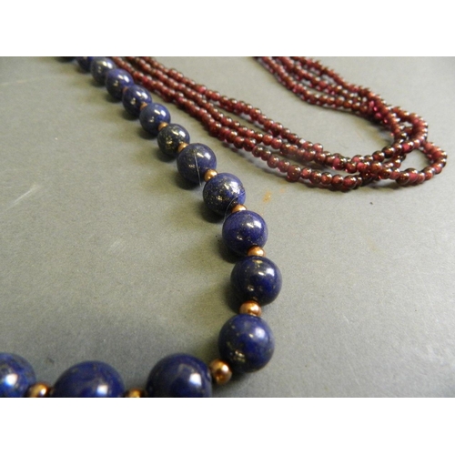 578 - A lapis lazuli bead necklace, and a three strand garnet bead necklace, longest 21