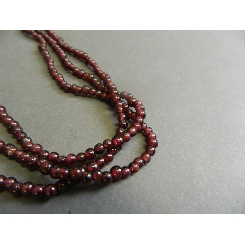 578 - A lapis lazuli bead necklace, and a three strand garnet bead necklace, longest 21