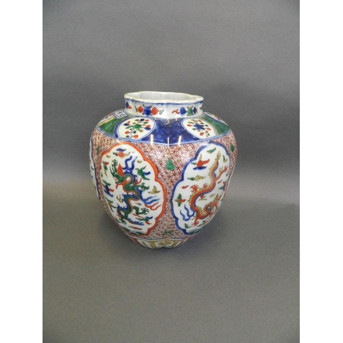 63 - A Chinese Wucai enamel porcelain jar of ribbed form with decorative panels depicting dragons chasing... 