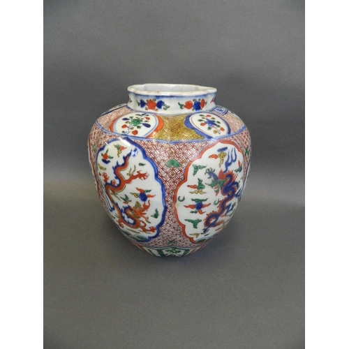 63 - A Chinese Wucai enamel porcelain jar of ribbed form with decorative panels depicting dragons chasing... 