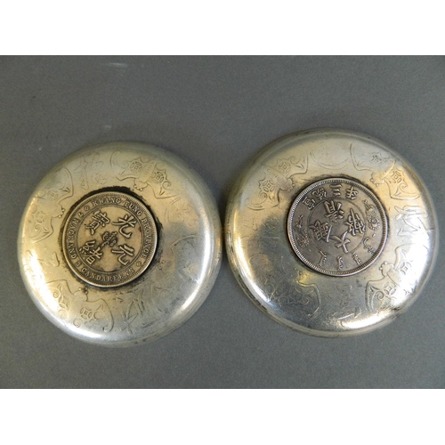 69 - Two Chinese white metal coin dishes decorated with dragons and bats, 3½