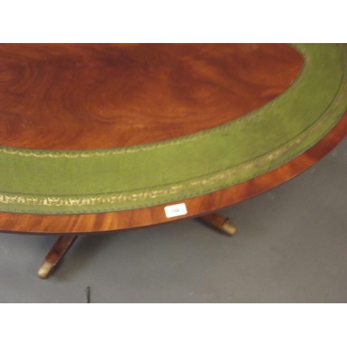 708 - A mahogany oval shaped occasional table with inset leather top, raised on a turned column and splay ... 