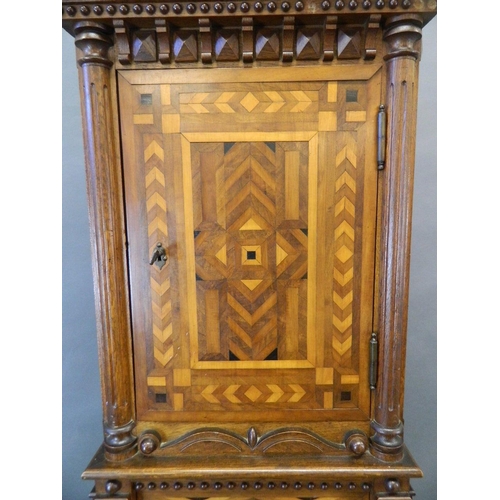 713 - A C19th Italian oak two section cabinet with parquetry inlaid panels and moulded and beaded decorati... 