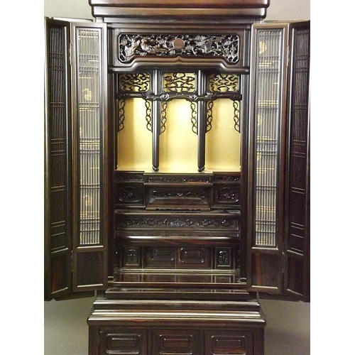 743 - A Chinese hardwood Butsudan shrine cabinet with sectional interior enclosed by two grilled doors on ... 