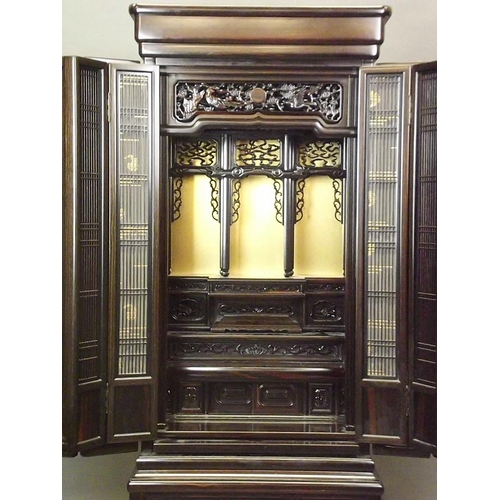 743 - A Chinese hardwood Butsudan shrine cabinet with sectional interior enclosed by two grilled doors on ... 