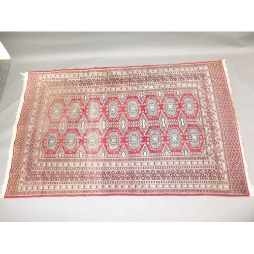 772 - A Turkish hand woven wool carpet with medallion designs on a red ground, 45