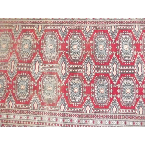 772 - A Turkish hand woven wool carpet with medallion designs on a red ground, 45