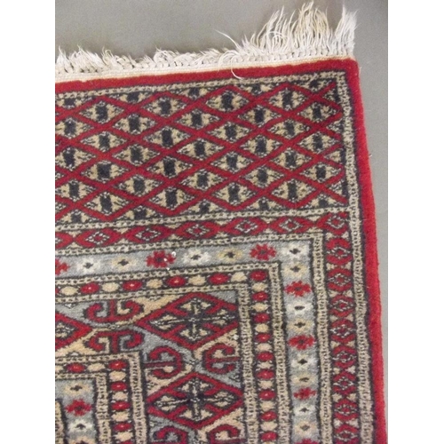 772 - A Turkish hand woven wool carpet with medallion designs on a red ground, 45