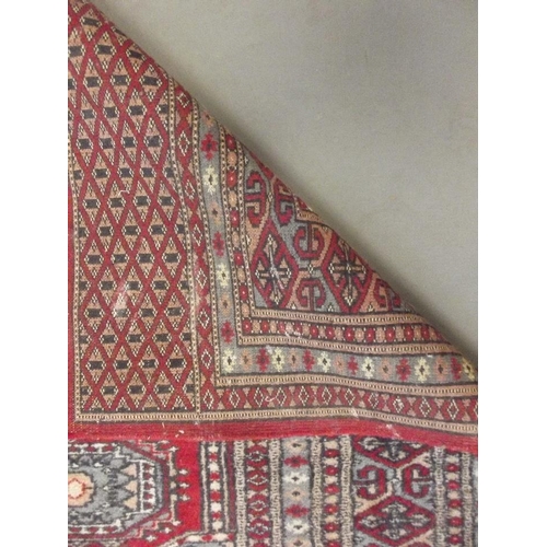 772 - A Turkish hand woven wool carpet with medallion designs on a red ground, 45