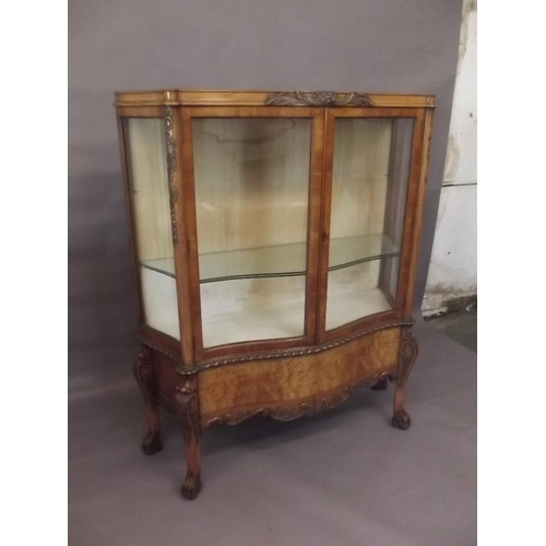 785 - A late C19th/early C20th figured walnut serpentine shaped display cabinet with shaped sides and carv... 