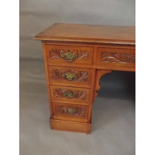 798 - A Victorian mahogany nine drawer kneehole desk of small proportions, with carved decoration, raised ... 