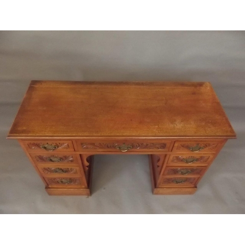 798 - A Victorian mahogany nine drawer kneehole desk of small proportions, with carved decoration, raised ... 