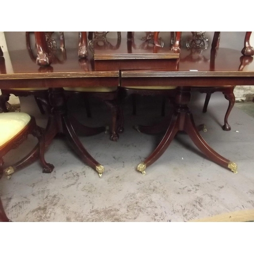 823 - A Georgian style mahogany twin pedestal dining table with inlaid cross banded top and an extra leaf,... 