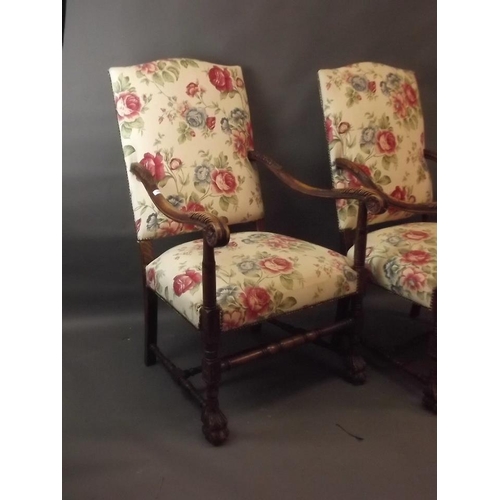 853 - A pair of stained beech wood open arm chairs with carved decoration, raised on paw feet