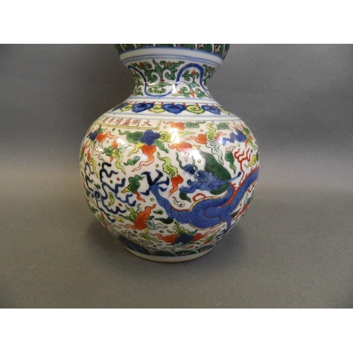 86 - A Chinese Doucai enamelled porcelain double gourd vase decorated with dragons chasing the flaming pe... 