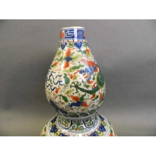 86 - A Chinese Doucai enamelled porcelain double gourd vase decorated with dragons chasing the flaming pe... 