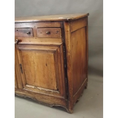 864 - An early C20th French fruitwood buffet with three drawers over two panelled doors, with a shaped car... 