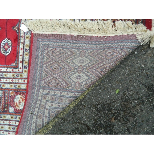 882 - A large red ground Kashmir carpet with ivory Bukhara design, 108