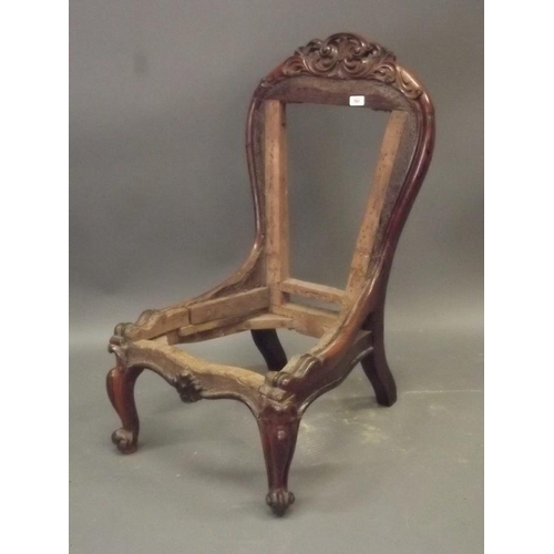 913 - An early Victorian rosewood nursing chair with carved and pierced crest back, raised on carved cabri... 