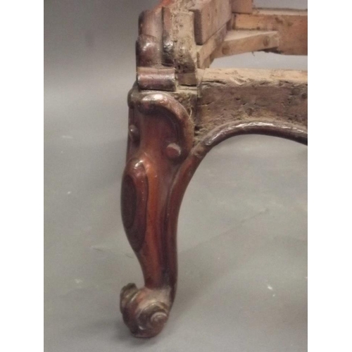 913 - An early Victorian rosewood nursing chair with carved and pierced crest back, raised on carved cabri... 