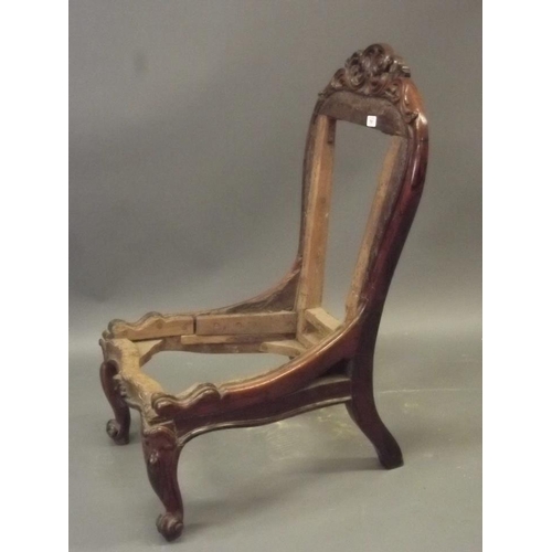 913 - An early Victorian rosewood nursing chair with carved and pierced crest back, raised on carved cabri... 