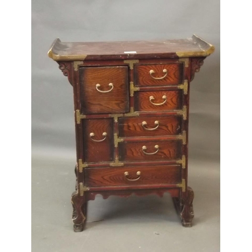 914 - A small Japanese ash cabinet with brass mounts, raised on carved and shaped supports, 21