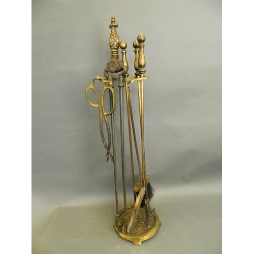 917 - A brass companion set stand, together with a collection of brass and steel fire tools, 27½