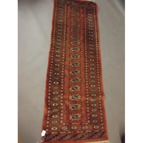 920 - A Turkish hand woven wool runner with medallion design on a rust red field, 24