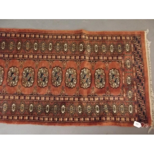 920 - A Turkish hand woven wool runner with medallion design on a rust red field, 24