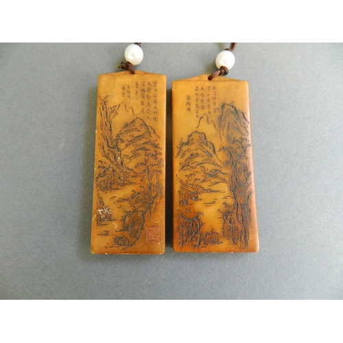 99 - A Chinese amber soapstone seal with engraved landscape decoration, and another similar, 3