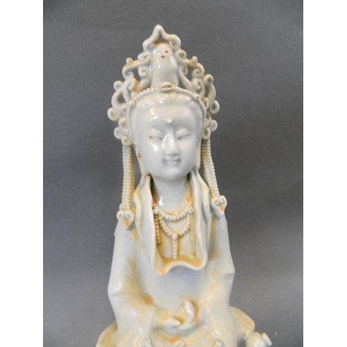 101 - A Chinese celadon glazed porcelain figure of Quan Yin seated in meditation, 9½