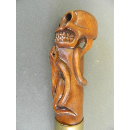 114 - A wood handled Malacca walking stick carved in the form of a skull and two snakes, 36