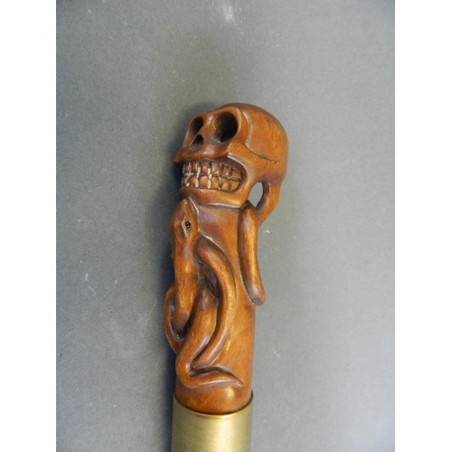 114 - A wood handled Malacca walking stick carved in the form of a skull and two snakes, 36