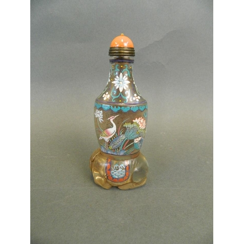 132 - An unusual Chinese glass snuff bottle with carved base in the form of an elephant and painted enamel... 